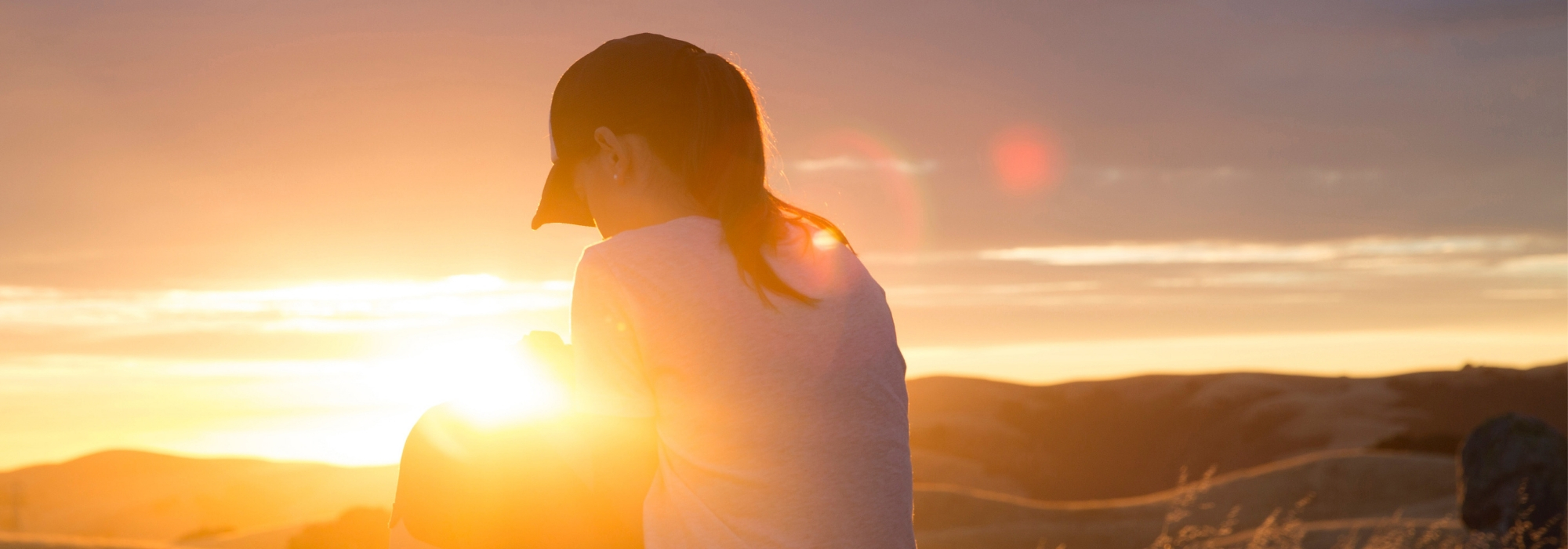 Frau betet im Sonnenuntergang oder Sonnenaufgang